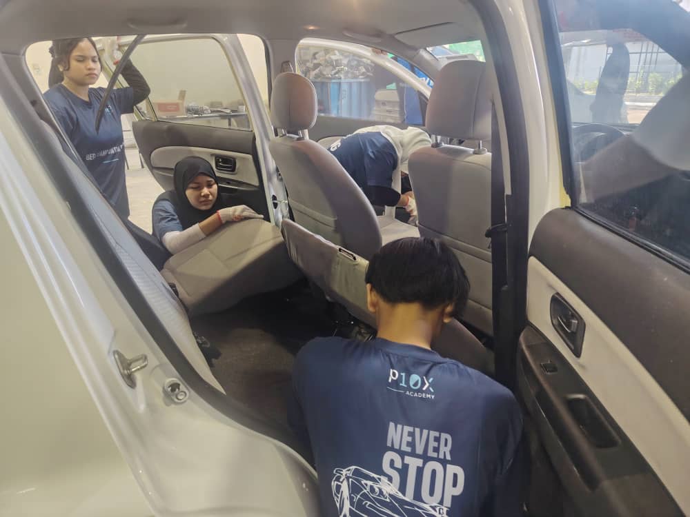 Pelajar P10X Academy mengeluarkan tempat duduk kereta untuk latihan detailing dalaman penuh