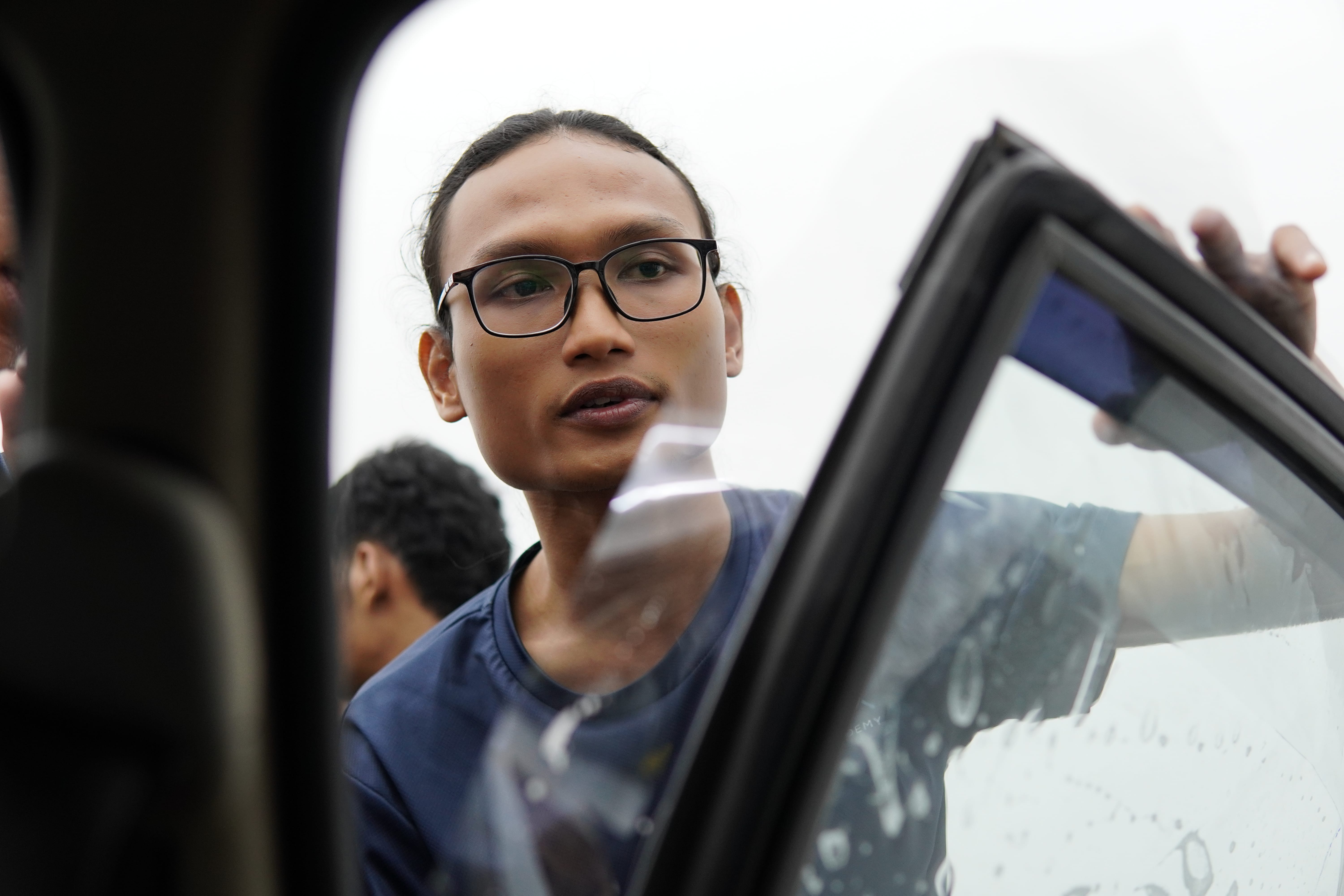 Pelajar lelaki P10X Academy memasang tinted pada cermin sisi kereta