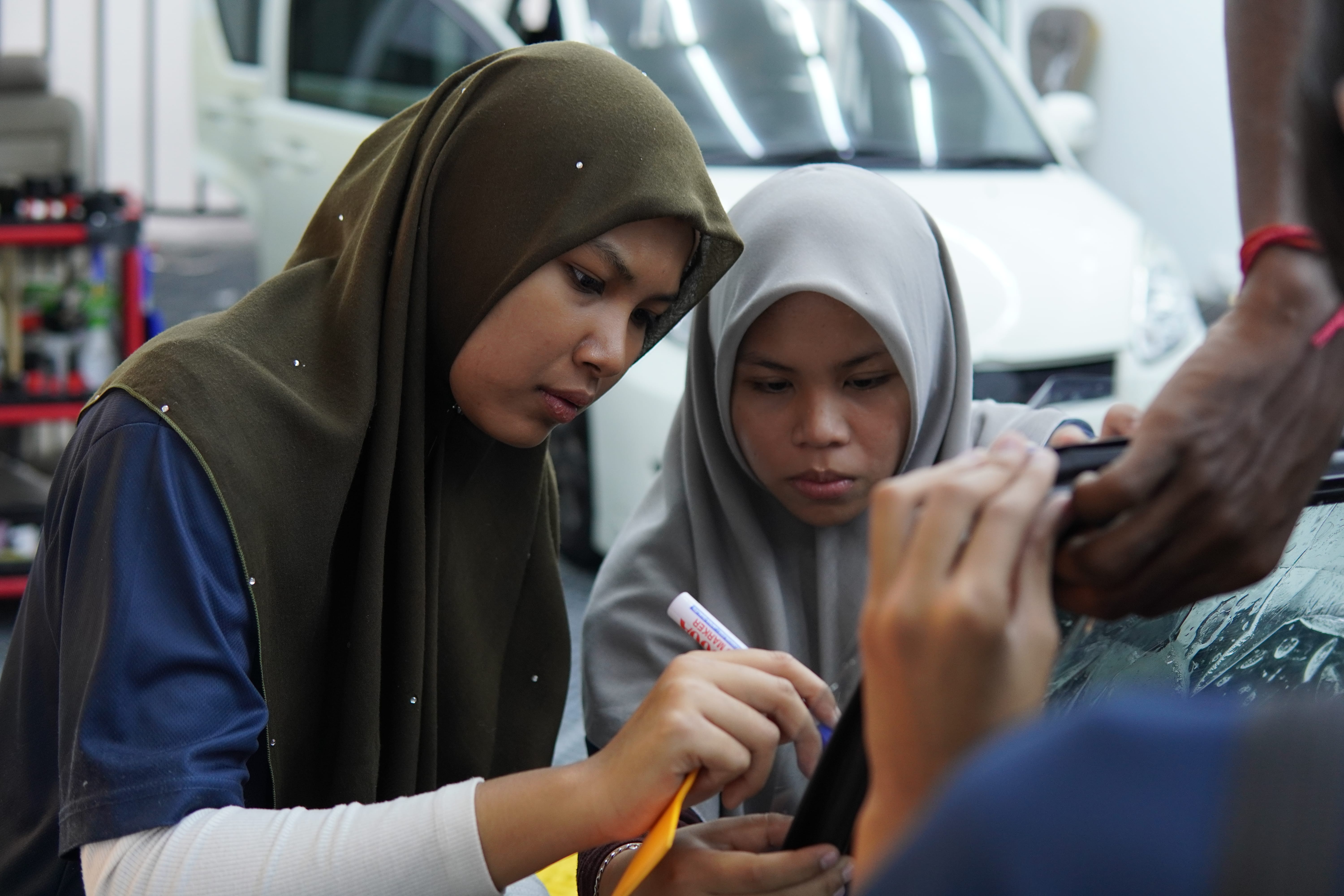 Pelajar wanita P10X Academy berbincang semasa sesi praktikal tinted